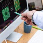 Hand met pen die naar beeldscherm met website afbeelding wijst