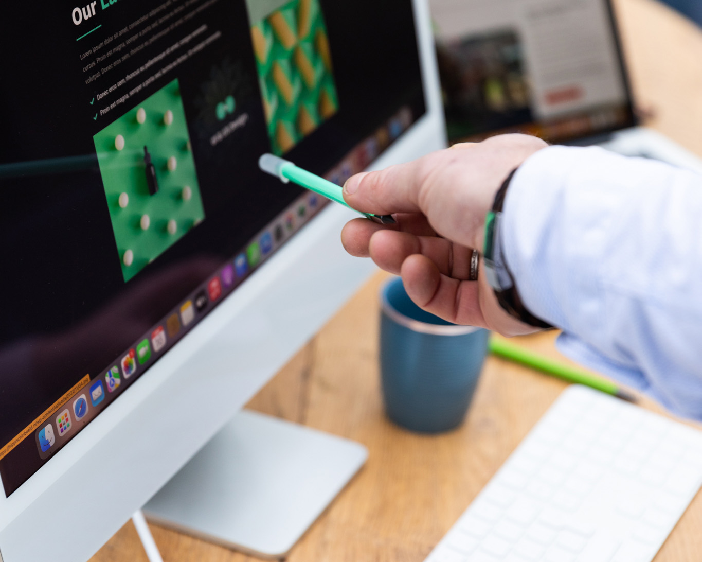 Hand met pen die naar beeldscherm met website afbeelding wijst