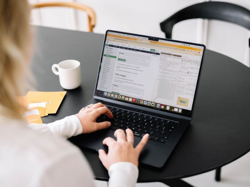 Anneke die aan een laptop werkt aan een website